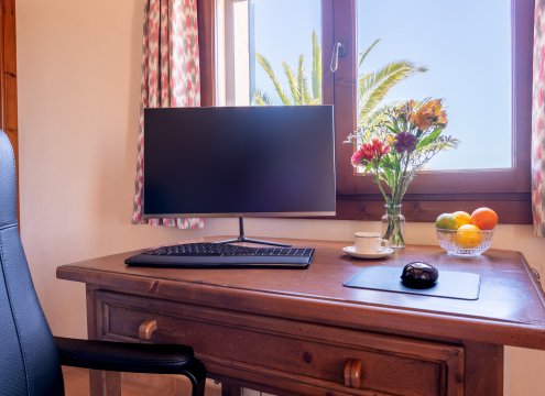 Professioneller Arbeitsplatz im Hauptschlafzimmer in ruhiger Lage mit antikem Holzschreibtisch, Monitor und ergonomischem Stuhl (optionales Upgrade) mit schönem Blick