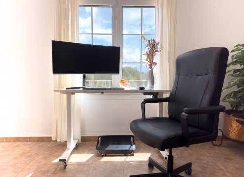 Arbeitsplatz im unteren Wohnzimmer mit schönem Blick auf den Pool und die Landschaft mit höhenverstellbarem Schreibtisch, ergonomischem Bürostuhl und Widescreen (optional buchbar)