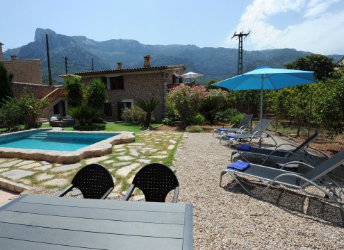 Angenehmer Garten mit Liegestühlen und Essbereich im Freien mit Blick auf das Tramuntana-Gebirge