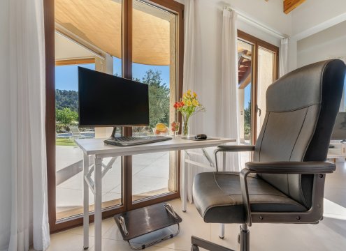 Beispiel optionaler Arbeitsplatz im Wohnzimmer mit schönem Blick auf den Pool und den grünen Garten