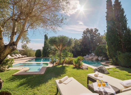 Sonnenliegen und eine Liegewiese am Pool, die zum Genießen der Natur einlädt