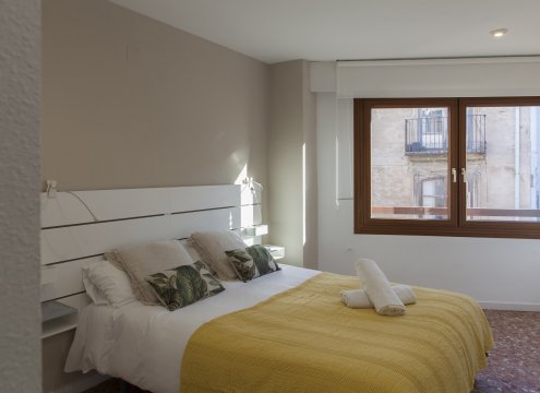 Geräumiges Schlafzimmer mit gemütlichem Bett. Vor dem großen Fenster kann ein optional Arbeitsplatz ein ruhig gelegener Arbeitsbereich eingerichtet werden.